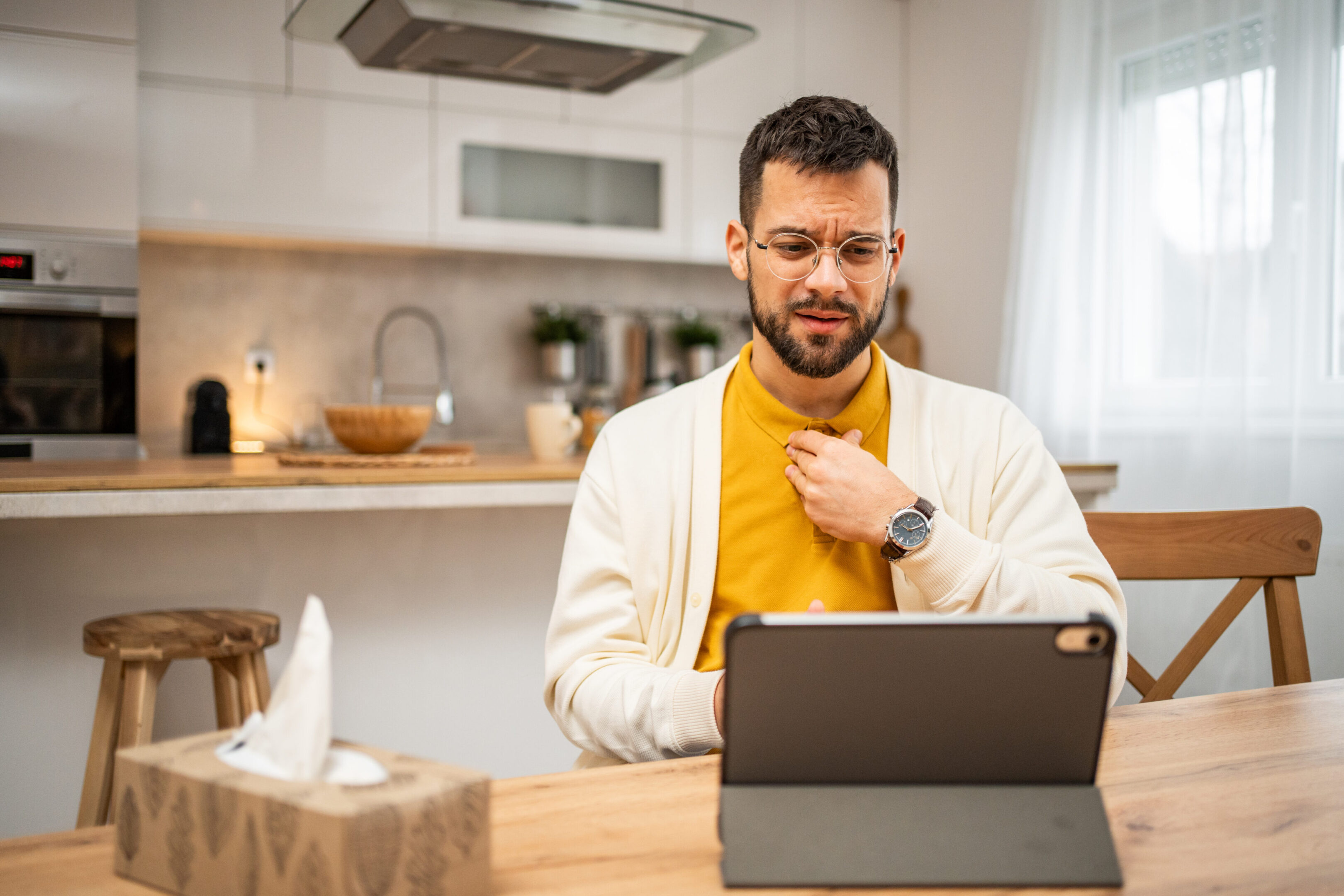 A young white man using a tablet to communicate with his psychotherapist. Communicates at a distance